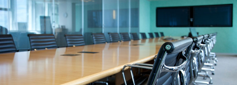Image of boardroom with videoconferencing LCD screens