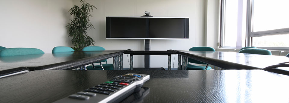 Image of meeting room with videoconferencing LCD screens